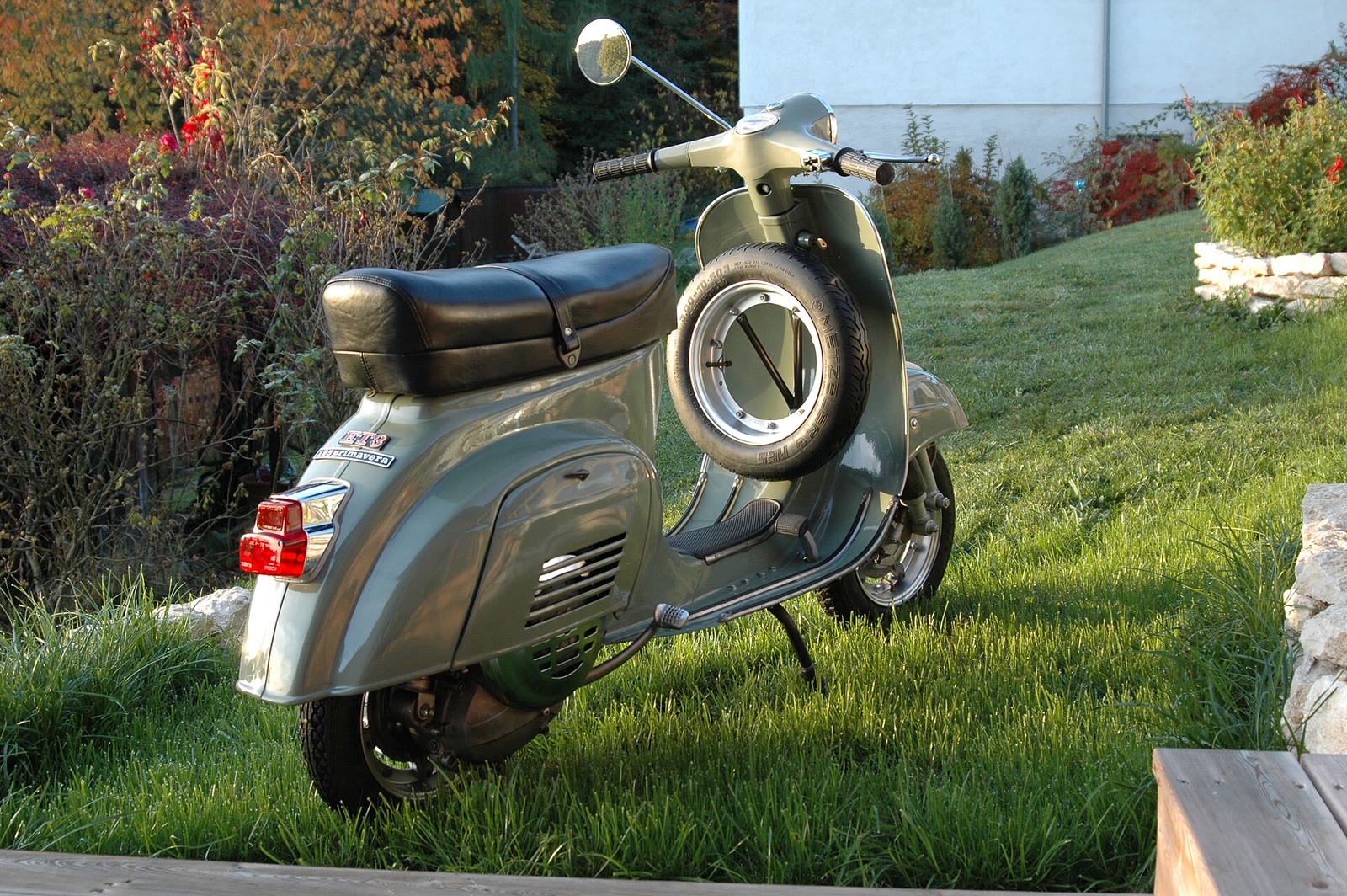 Vespa Primavera ET3 verde in un giardino (2/2)