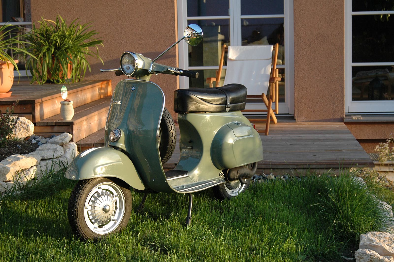 Vespa Primavera ET3 verde in un giardino
