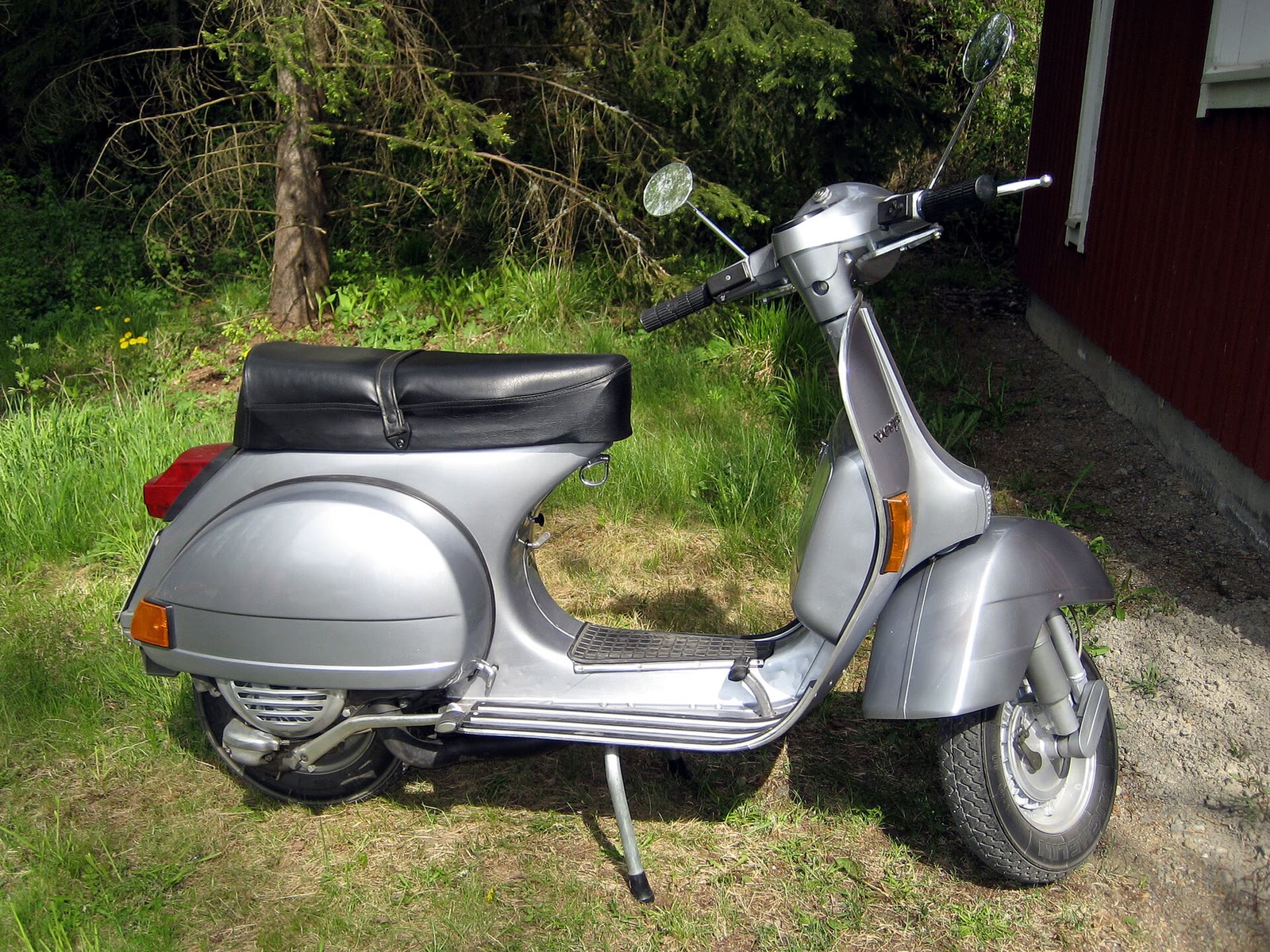 Vespa P 200 E grigia su un prato
